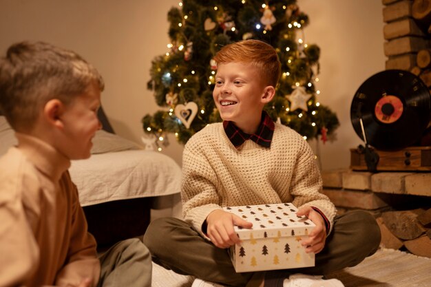 Vue de face enfant souriant tenant un cadeau