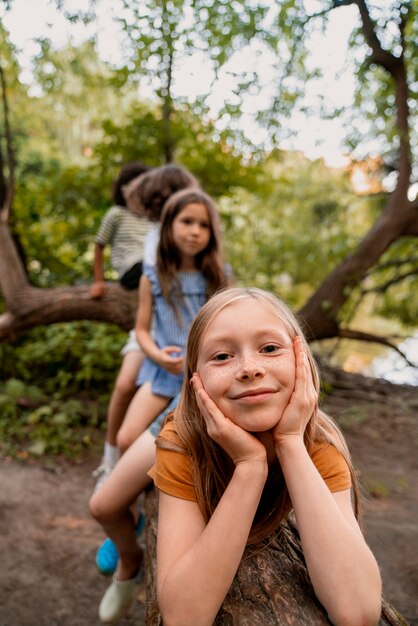 Vue de face des enfants assis sur une bûche