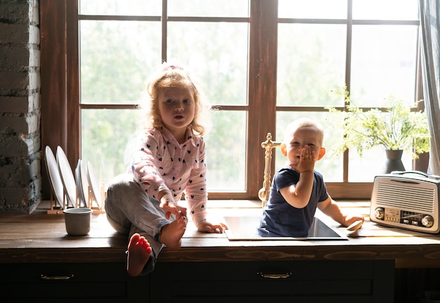 Photo gratuite vue de face des enfants assis sur un comptoir