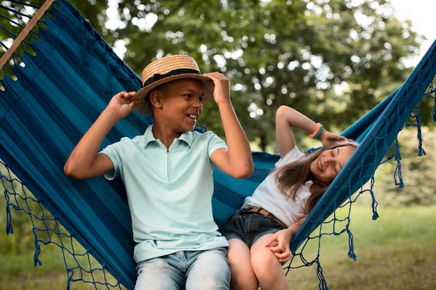 Vue de face d'enfants heureux dans un hamac