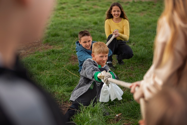 Vue de face des enfants jouant au tir à la corde dans le parc