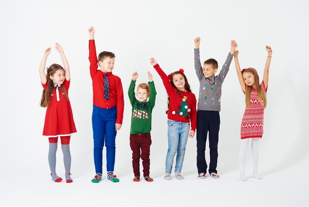 Vue de face des enfants les mains debout dans une rangée