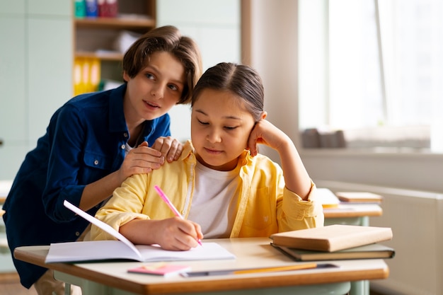 Photo gratuite vue de face des enfants trichent à l'école