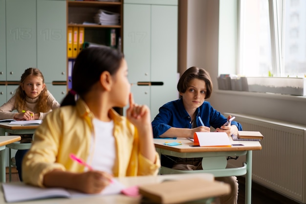 Photo gratuite vue de face des enfants trichent à l'école