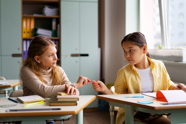 Photo gratuite vue de face des enfants trichent à l'école