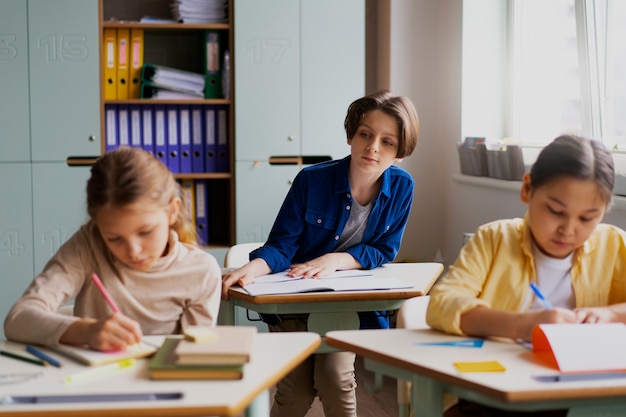 Photo gratuite vue de face des enfants trichent à l'école