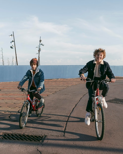 Vue de face des enfants sur les vélos à l'extérieur avec copie espace