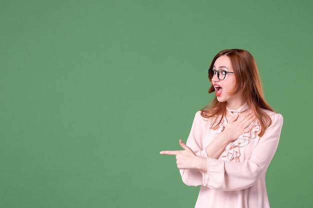 Vue De Face Enseignante En Chemisier Rose Posant Sur Fond Vert Travail école Femme Couleur Jeune étudiant Travail Livre De Leçon