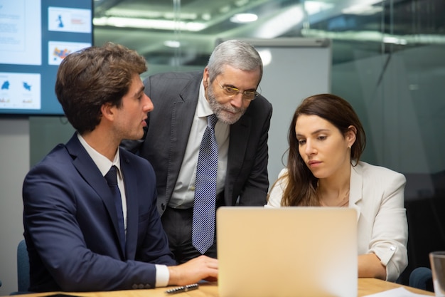 Vue De Face De L'équipe Commerciale Confiante Regardant Un Ordinateur Portable