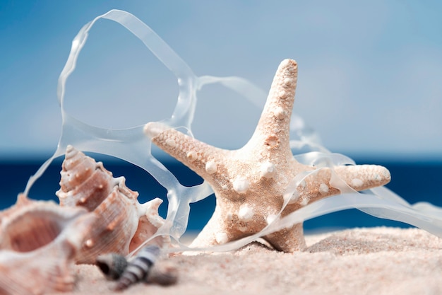 Vue de face de l'étoile de mer avec du plastique sur la plage