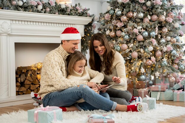 Vue de face de la famille et de l'arbre de Noël