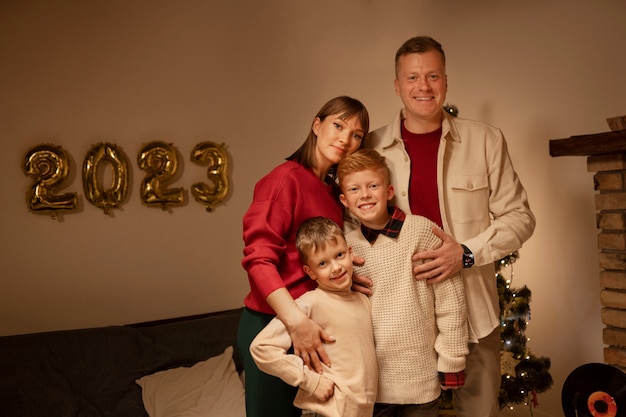 Photo gratuite vue de face famille heureuse posant à l'intérieur