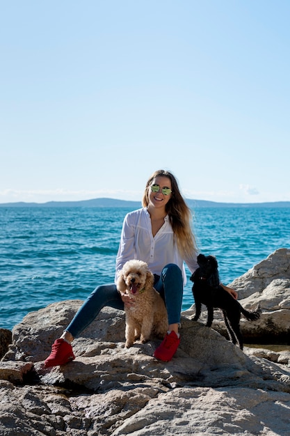 Vue de face femelle avec caniche au bord de mer