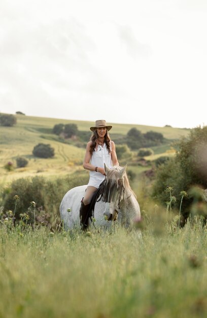 Vue de face de la femme agricultrice équitation