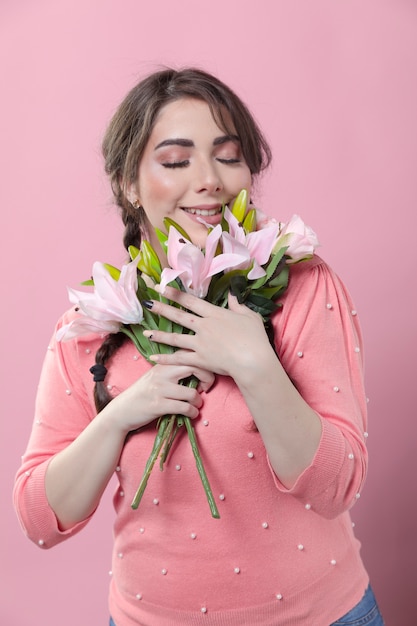 Photo gratuite vue de face de femme aimant son bouquet de lys