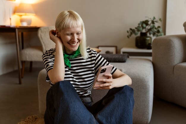 Vue de face femme albinos tenant un smartphone