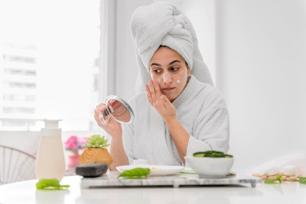 Vue de face femme appliquant la crème pour le visage