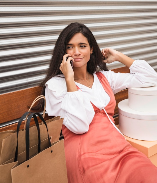 Photo gratuite vue de face de la femme assise sur un banc avec des boîtes