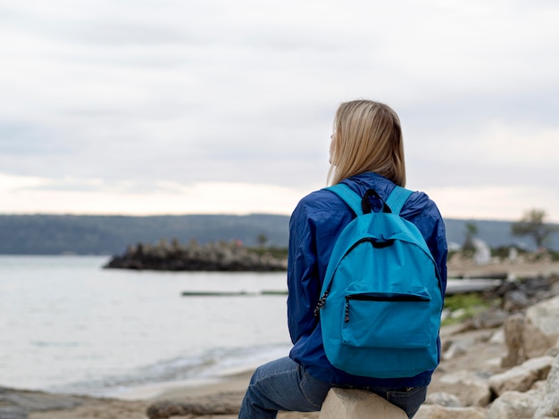 Vue de face femme assise sur des rochers