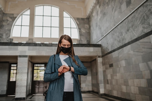 Photo gratuite vue de face femme en attente à l'intérieur de la gare