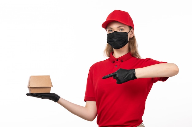 Une vue de face femme courrier en chemise rouge bonnet rouge gants noirs et masque noir tenant le paquet de nourriture sur blanc