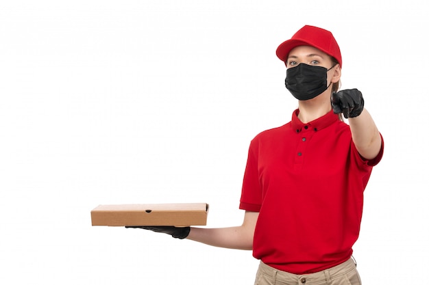 Une Vue De Face Femme Courrier En Chemise Rouge Carpe Rouge Gants Noirs Et Masque Noir Tenant La Boîte à Pizza Doigt Pointé Sur Blanc