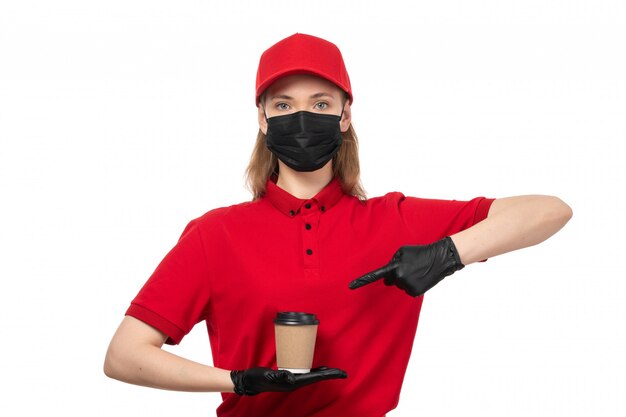 Une vue de face femme courrier en chemise rouge gants noirs bonnet rouge masque noir tenant du café sur blanc