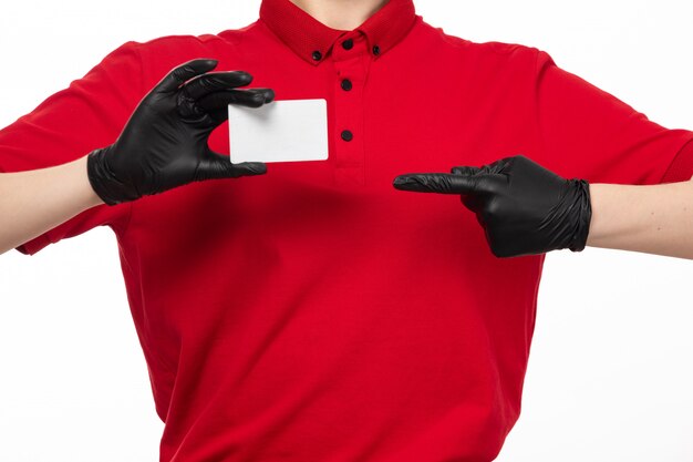 Une vue de face femme courrier en chemise rouge gants noirs tenant une carte blanche