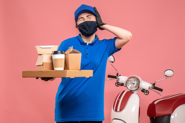 Vue de face femme courrier avec livraison de café et de nourriture sur le travail de la pandémie rose travailleur covid- service d'emploi uniforme