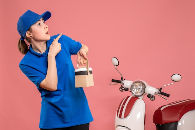 Vue de face femme courrier avec livraison de café sur le travail rose travailleur de livraison femme travail uniforme de vélo