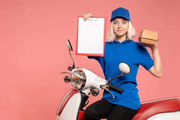 Vue de face femme courrier sur vélo avec petit paquet de nourriture sur le rose