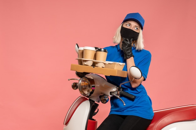 Vue de face femme courrier sur vélo avec tasses à café sur le rose