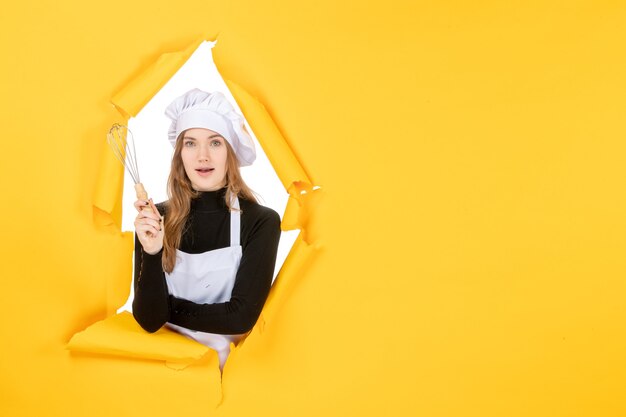 Vue de face femme cuisinier en chapeau de cuisinier blanc sur l'émotion jaune couleur des aliments cuisine cuisine travail photos soleil