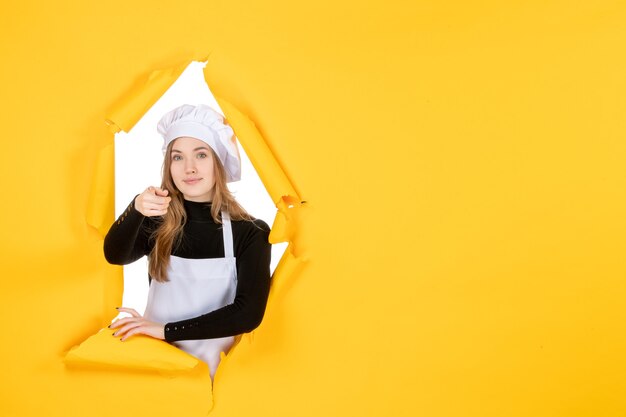 Vue de face femme cuisinier sur la couleur jaune soleil photo cuisine papier émotion travail alimentaire