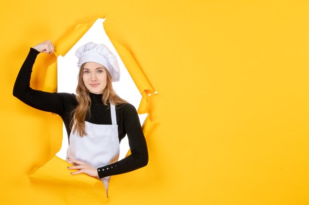 Vue de face femme cuisinier fléchissant et souriant sur jaune émotion couleur papier travail cuisine soleil nourriture photo