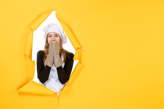 Vue de face femme cuisinier en gants de cuisinier et casquette de cuisinier blanc sur émotion jaune nourriture couleur cuisine cuisine travail photo soleil