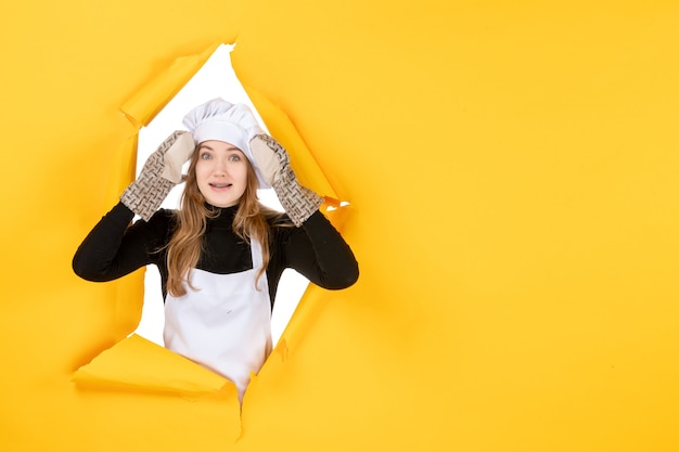 Vue de face femme cuisinier en gants de cuisinier et casquette de cuisinier blanc sur jaune soleil nourriture couleur cuisine photo émotion cuisine