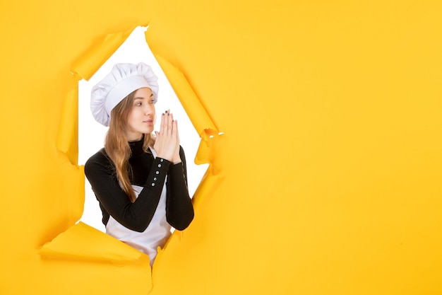 Vue de face femme cuisinier sur papier de couleur jaune soleil travail photo cuisine émotion alimentaire