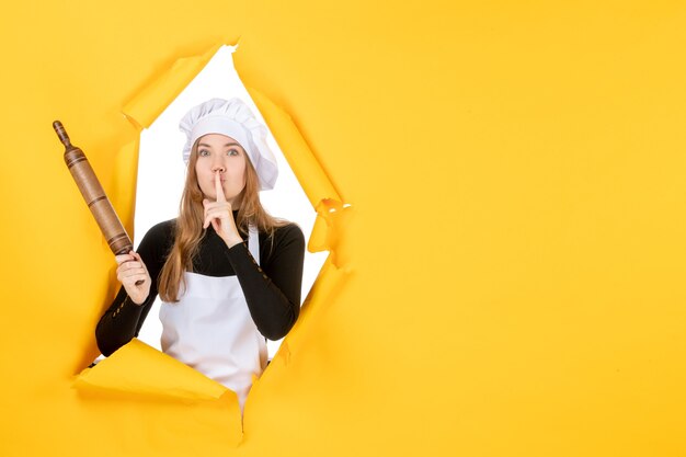 Vue de face femme cuisinier tenant un rouleau à pâtisserie sur le soleil jaune couleur alimentaire cuisine cuisine photo émotion