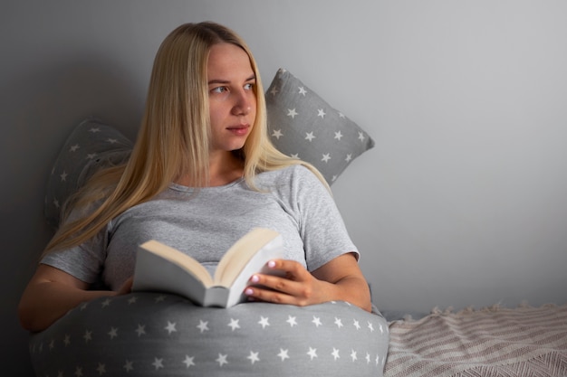 Photo gratuite vue de face femme enceinte à l'aide d'un coussin d'allaitement