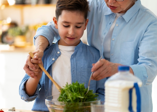 Photo gratuite vue de face femme et enfant cuisinant ensemble