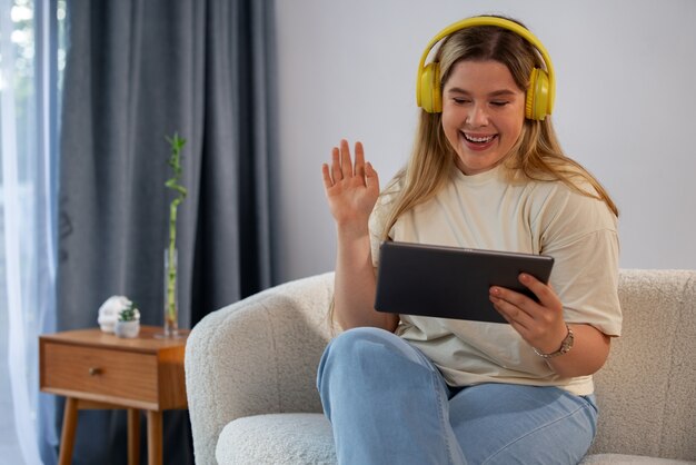 Vue de face femme faisant des appels vidéo avec tablette