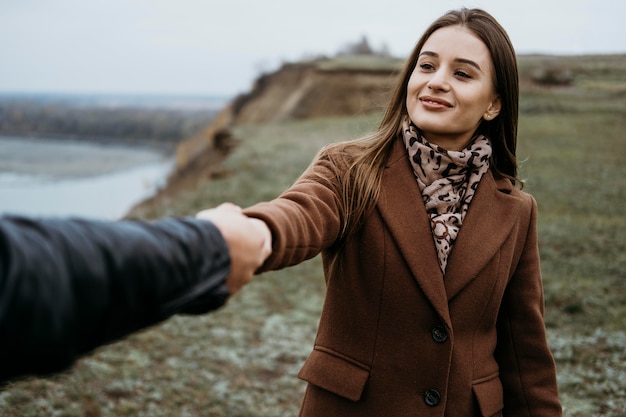 Vue de face de la femme faisant glisser son petit ami à l'extérieur