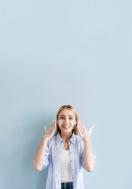 Vue de face de femme heureuse se laver les mains et le visage