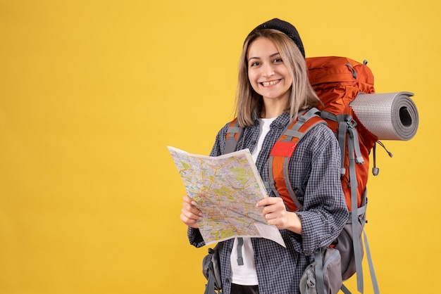 Vue de face d'une femme heureuse de voyageur avec sac à dos tenant la carte