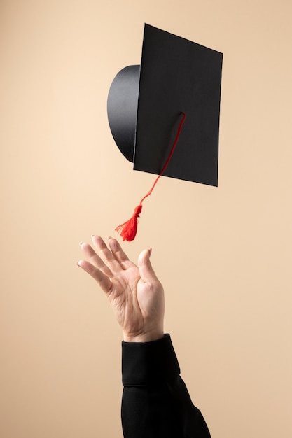 Vue de face d'une femme jetant une casquette de remise des diplômes pour la journée de l'éducation