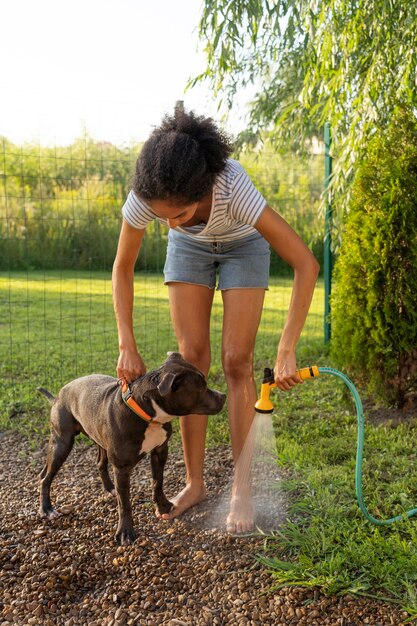 Vue de face femme lavant un chien à l'extérieur