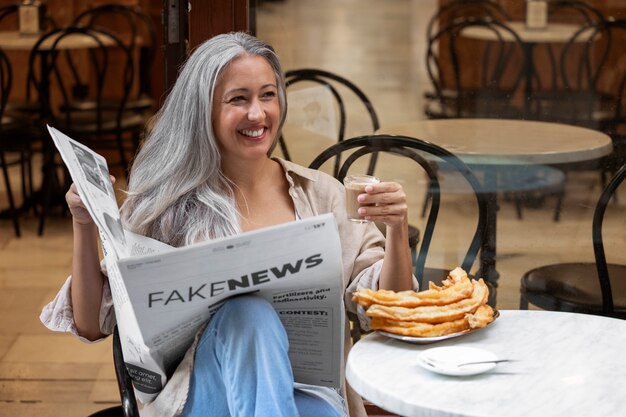 Photo gratuite vue de face femme lisant le journal