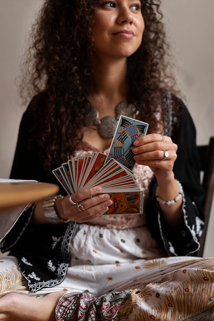 Vue de face femme lisant le tarot à la maison