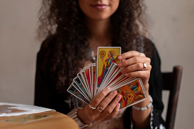 Vue de face femme lisant le tarot à la maison